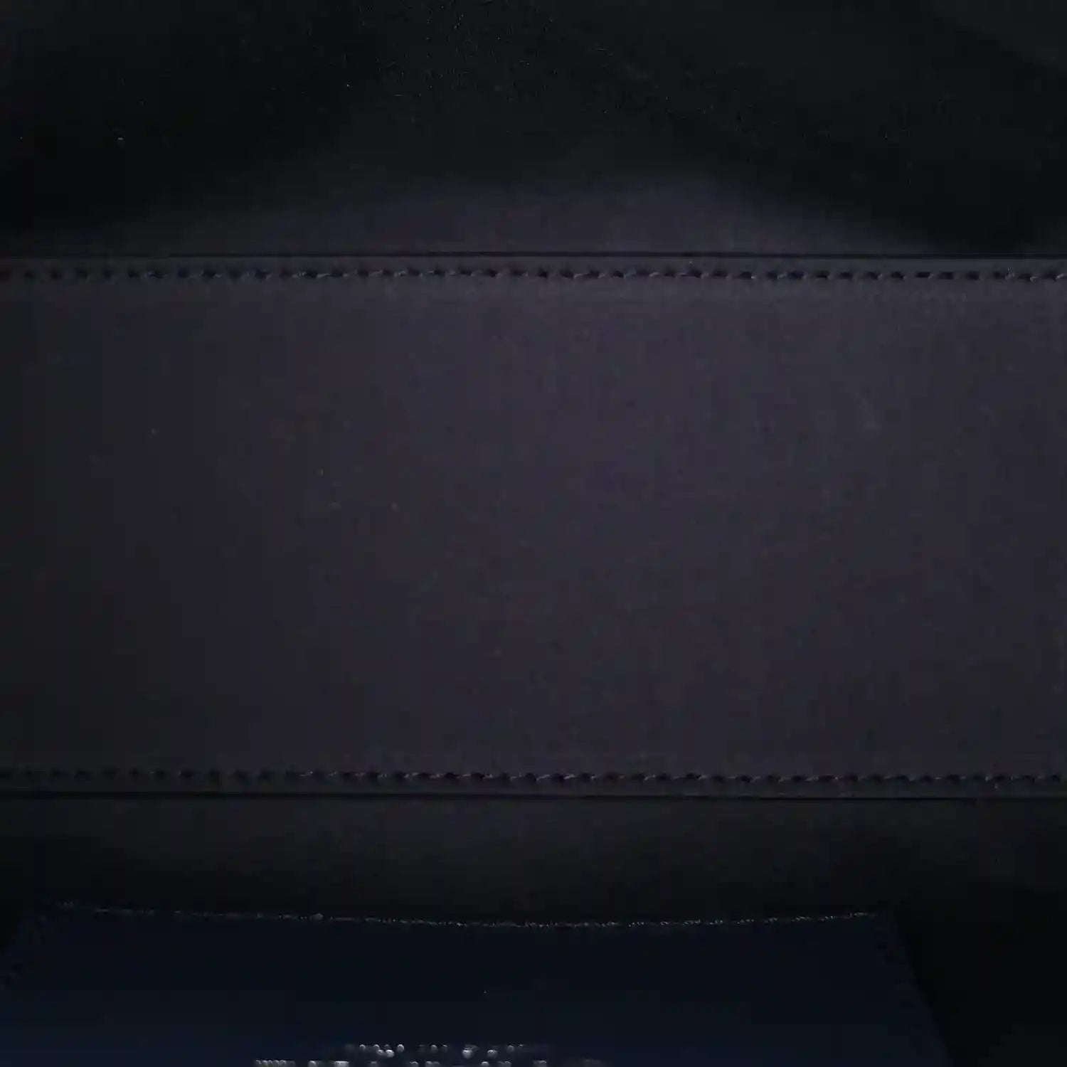 Handbag interior view with dark lining and stitched edge seam