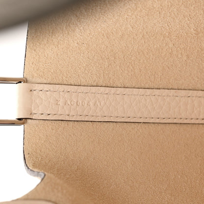 Nata leather handbag edge with woven trim and metal bar hardware near opening