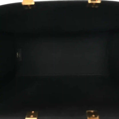 Black leather tote bag interior panel with small brand label near the edge