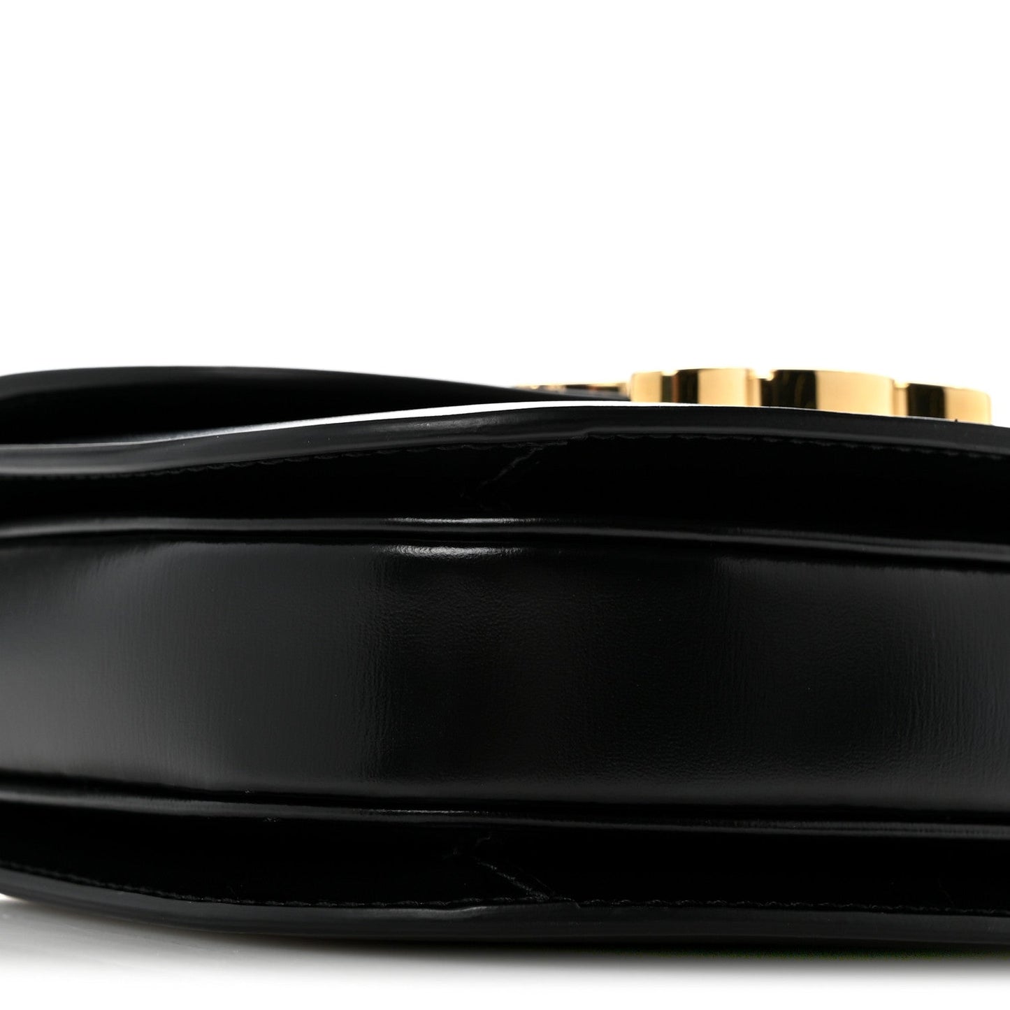 Black mini crossbody bag, close-up of smooth front panel and gold-tone trim