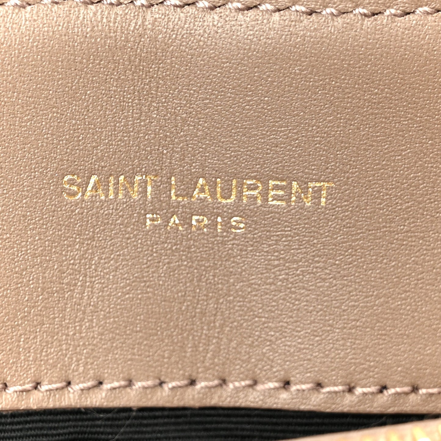 Taupe suede label with SAINT LAURENT PARIS text and stitched edge