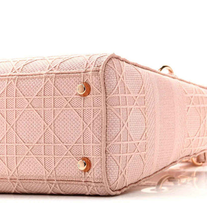 Pink canvas bag side panel with gold snaps and textured geometric embroidery
