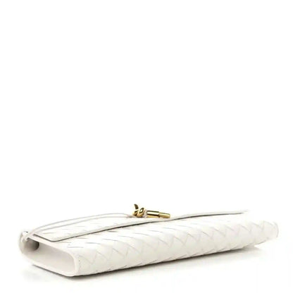 White nappa clutch with gold-tone clasp and woven texture on folded base