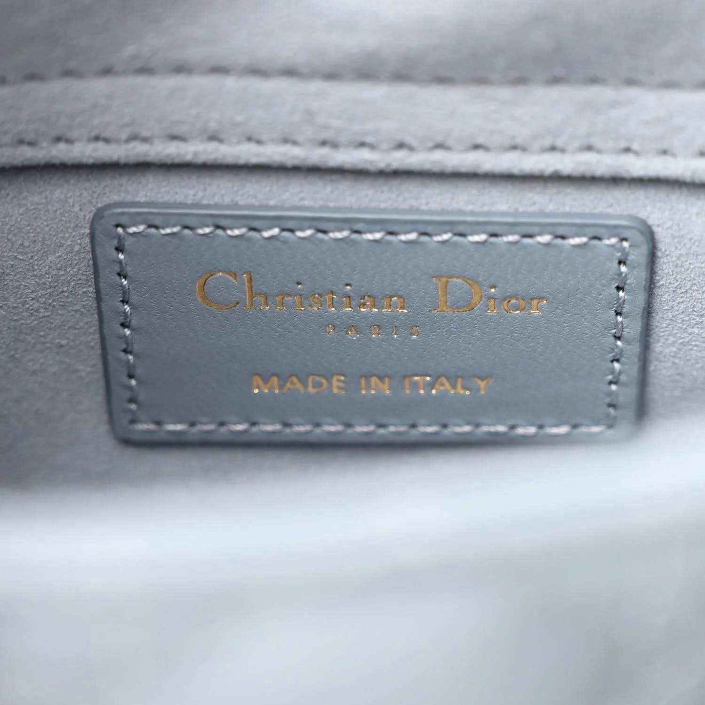 Christian Dior leather label on light blue bag, made in Italy text