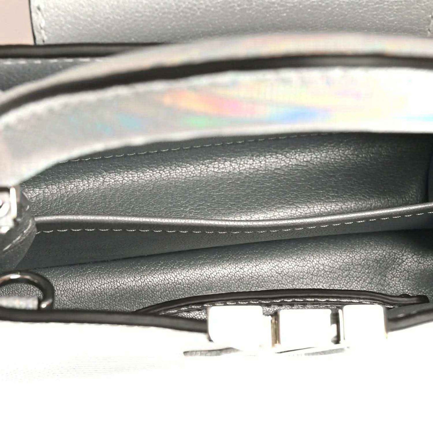 Mini handbag close-up of inner trim and metal clasp near top edge
