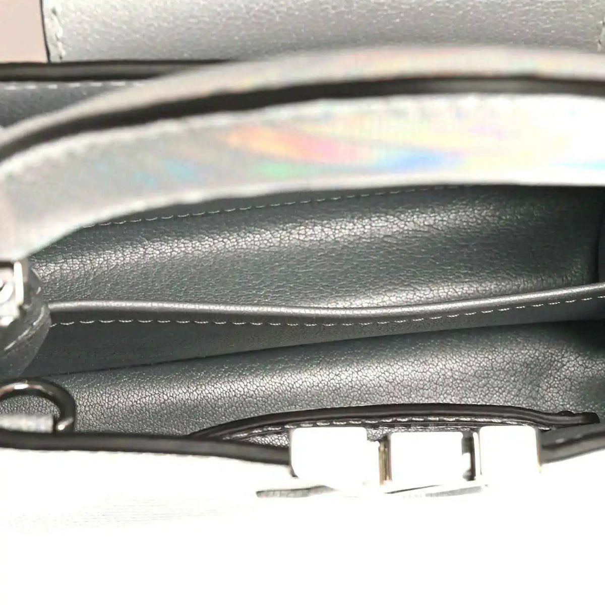 Mini handbag close-up of inner trim and metal clasp near top edge