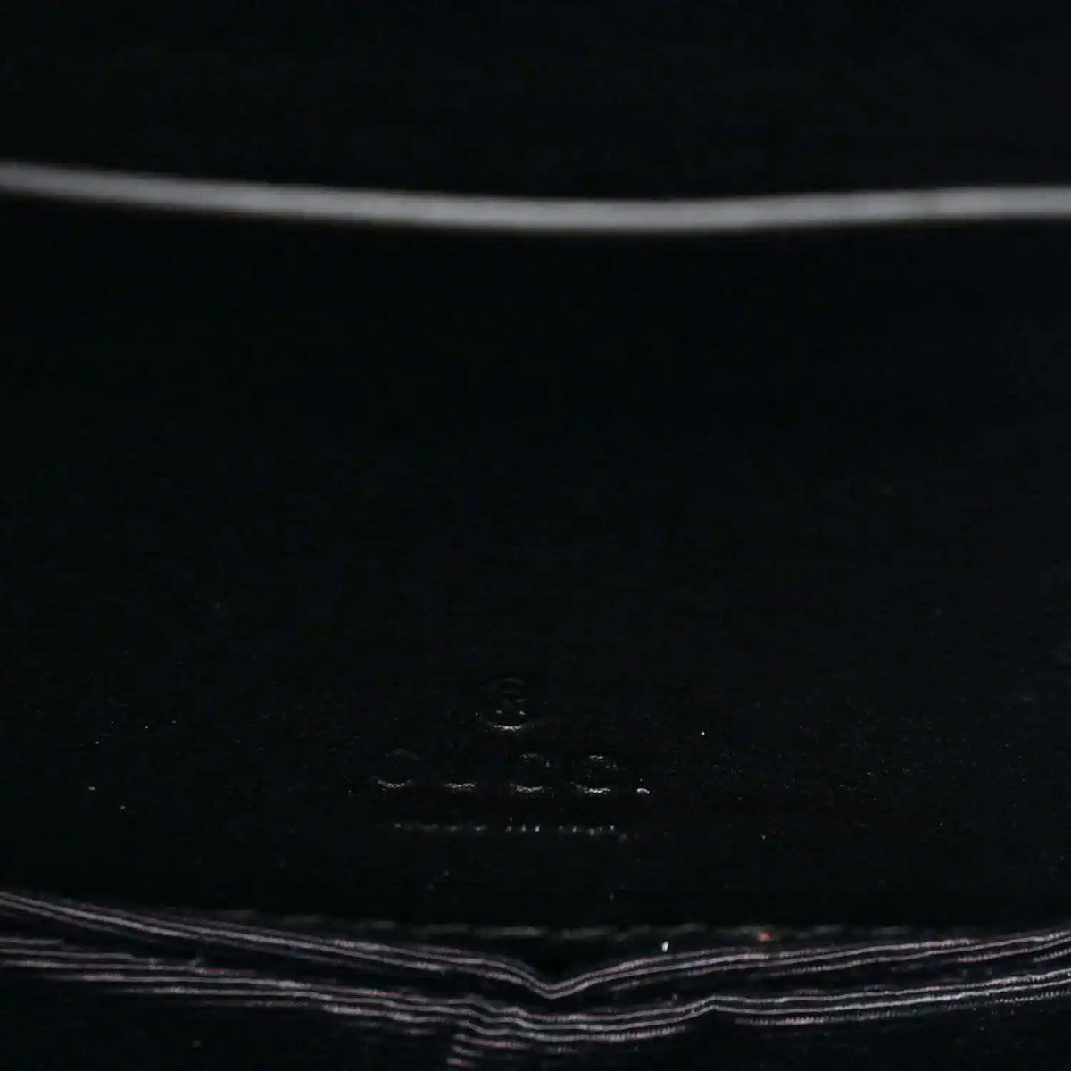 Close-up of black interior panel with small embossed logo text