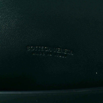 Emerald green nappa clutch bag with embossed brand mark on leather