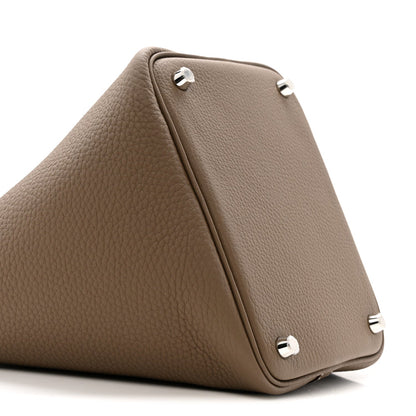 Etoupe leather bag corner with three metal feet and stitched trim