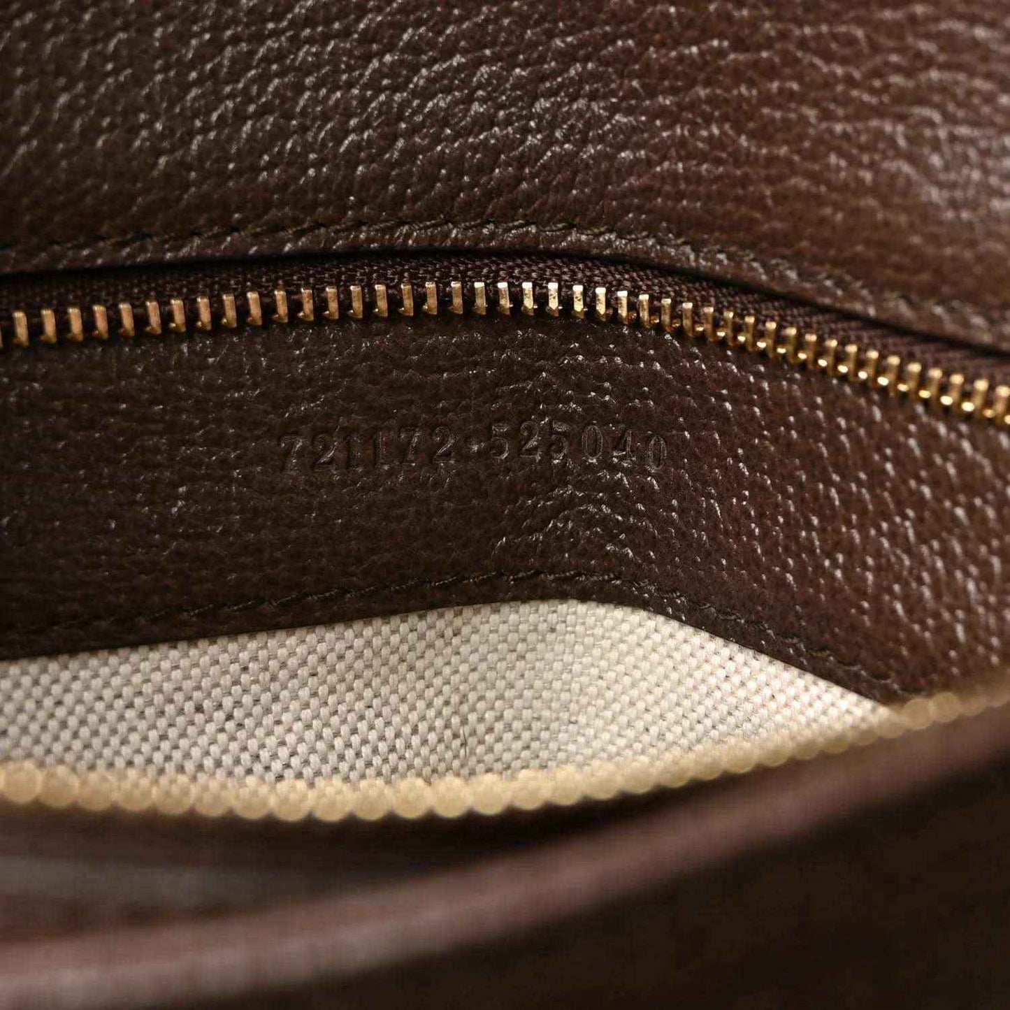 Medium top-handle bag inner lining detail with gold-tone zipper track and brown leather