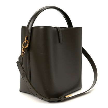 Saint Laurent bucket bag side view in deep musk leather with top handle and crossbody strap.