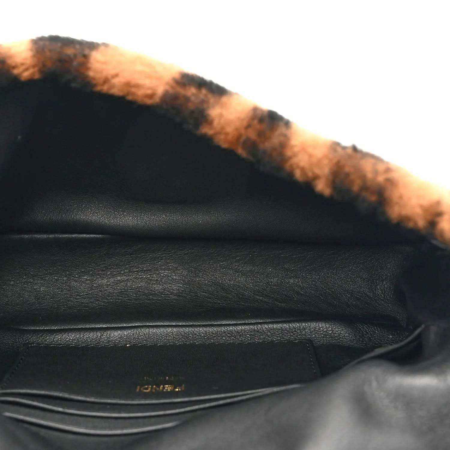 Black leather interior with shearling trim and stitching, close-up of mini bag.