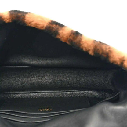 Black leather interior with shearling trim and stitching, close-up of mini bag.