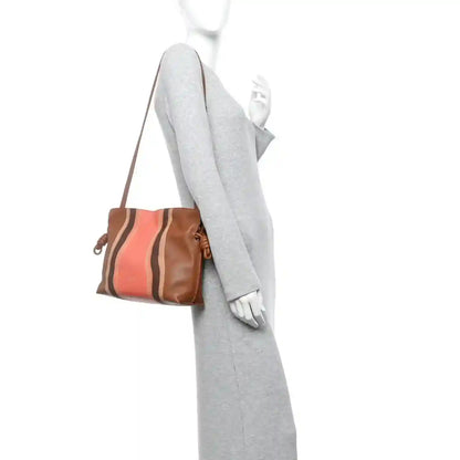 Flamenco knot clutch with adjustable shoulder strap, brown leather and coral striped front