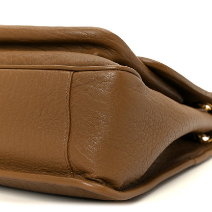 Grained leather satchel corner with edge stitching detail, dark cork.
