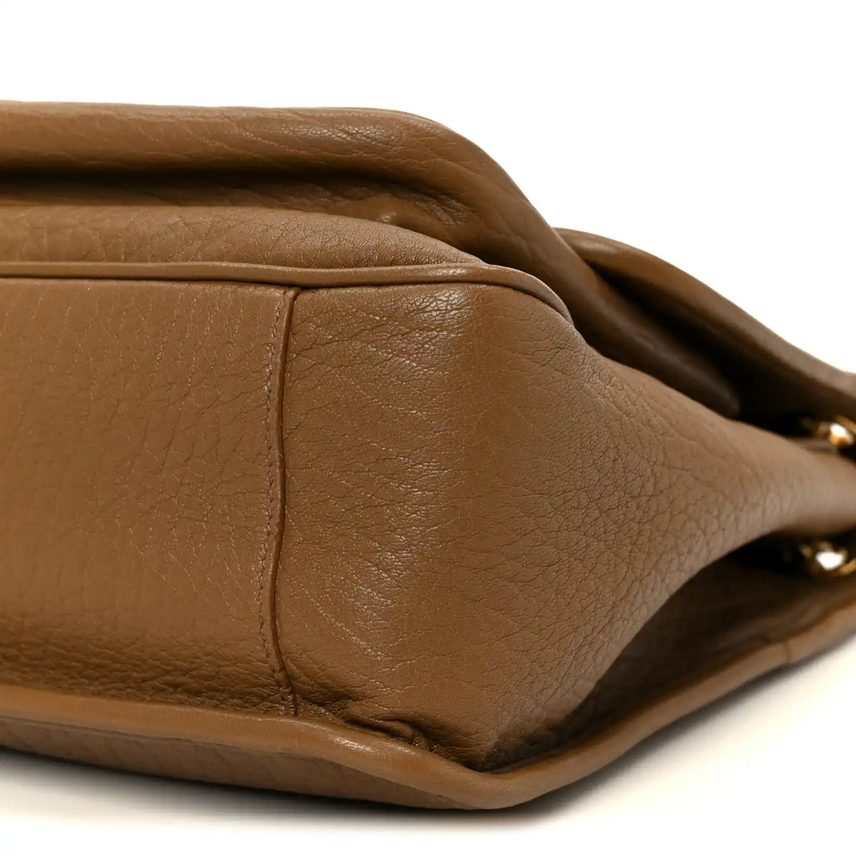 Grained leather satchel corner with edge stitching detail, dark cork.