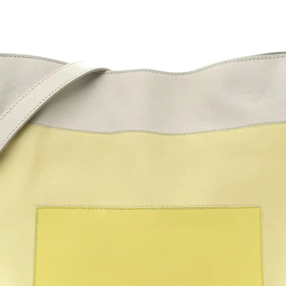 Front of knot clutch showing pale grey top and light citrine panel with stitching