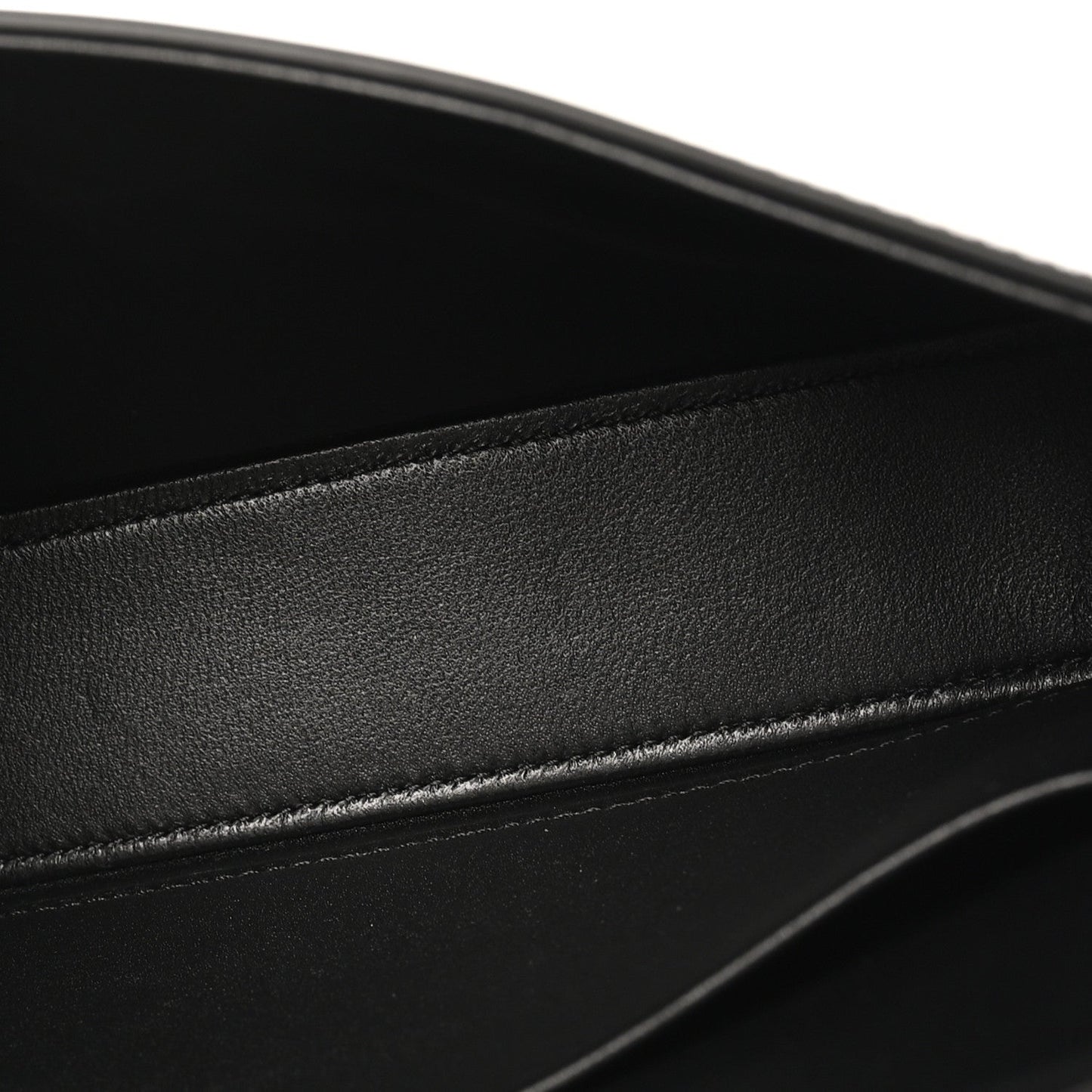 Black shiny calfskin leather close-up with stitched edge and smooth glossy finish