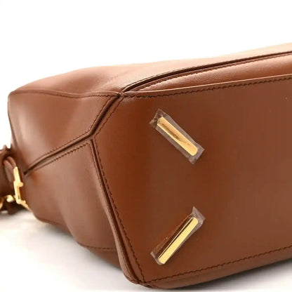 Pecan brown leather bag with gold-tone corner plaques and stitched panel lines