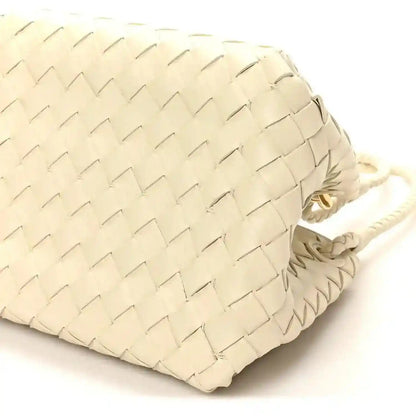 Light cream woven bag back panel close-up with braided cord handle