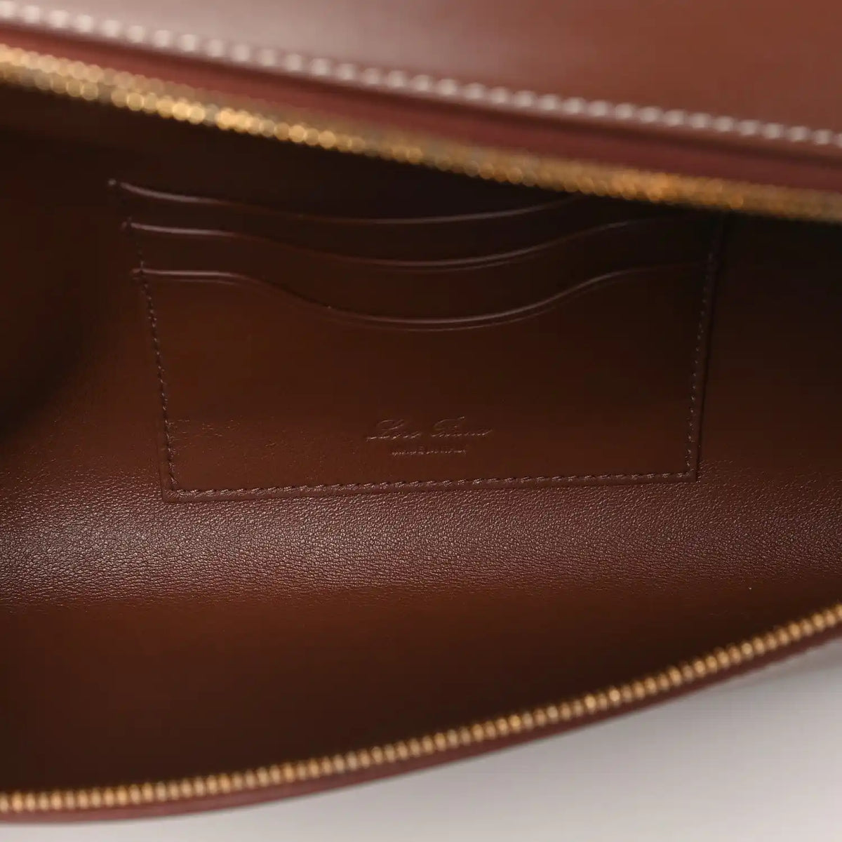 Loro Piana smooth calfskin clutch interior with stitched pocket and gold zipper trim
