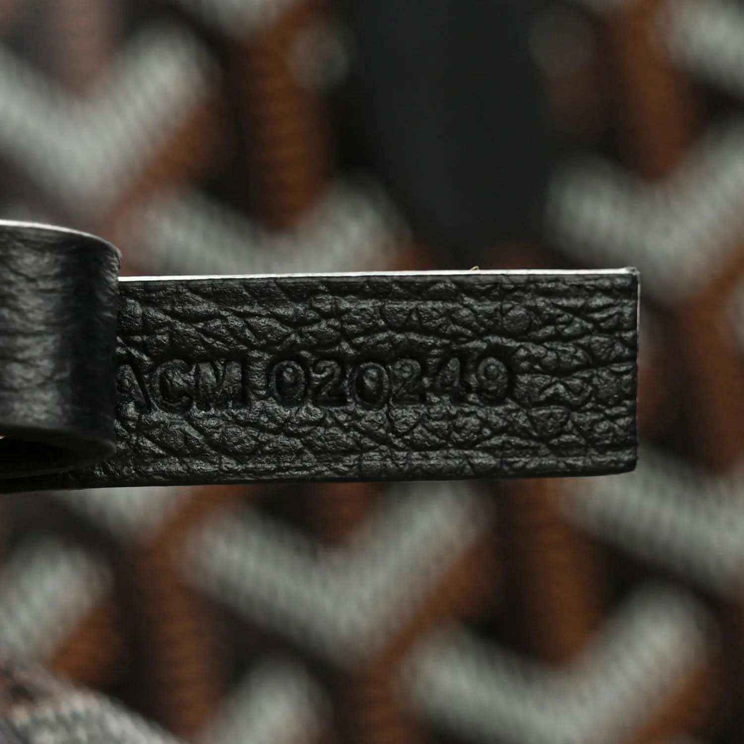 Black leather strap patch with embossed Goyard lettering on tote bag