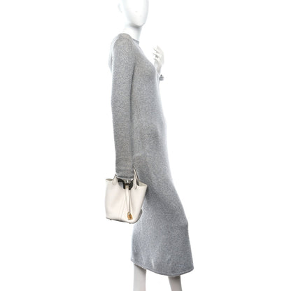 Pale cream leather mini tote bag with top handles and gold clasp, side view