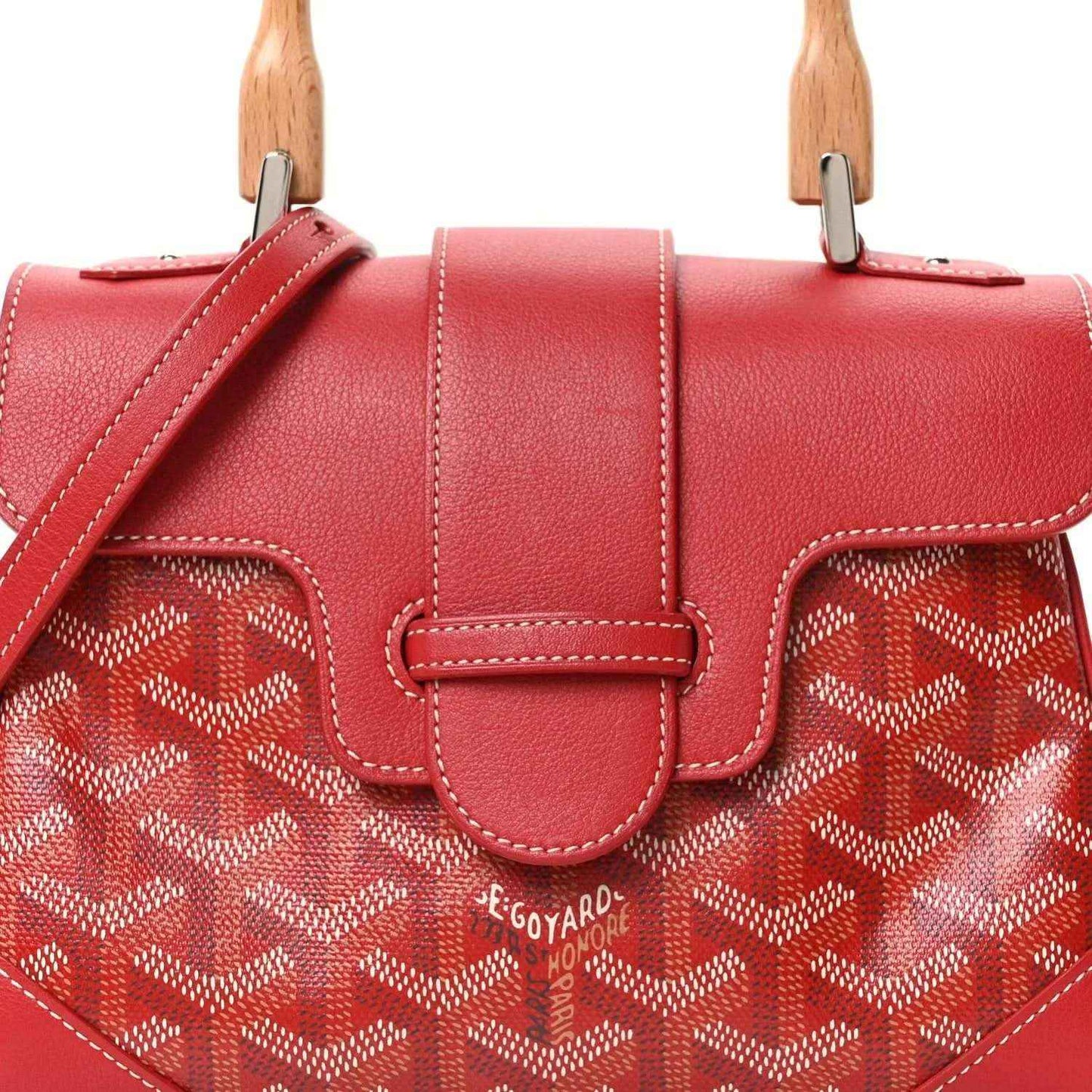 Red mini handbag front detail with leather clasp, stitched trim, and patterned coated canvas.