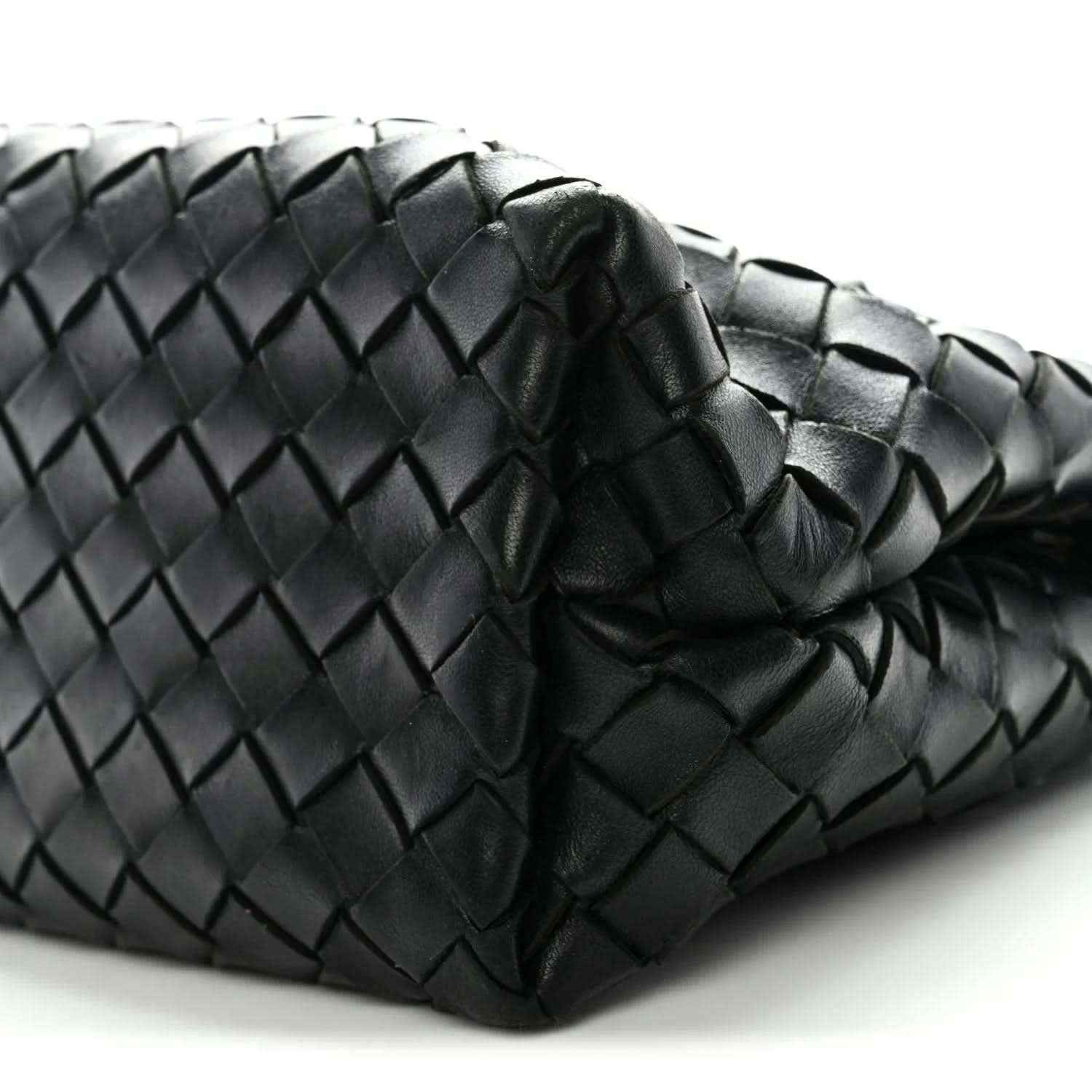 Black woven leather pattern detail with rounded folded corner