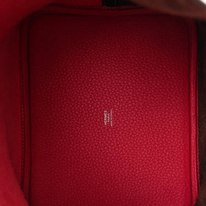 Red leather-lined interior of bucket bag with embossed logo text