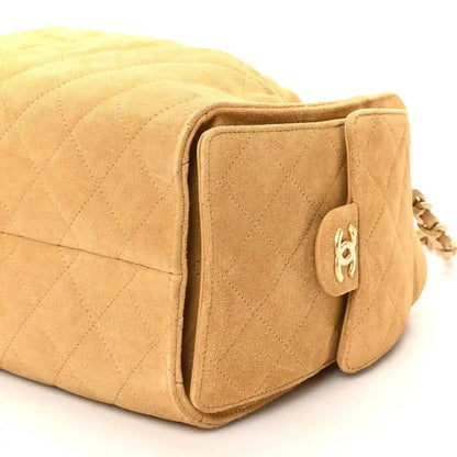 Chanel beige quilted suede handbag with front pocket, snap tab, and chain hardware