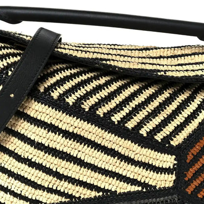 Small raffia puzzle bag front with black leather strap, natural and black chevron weave