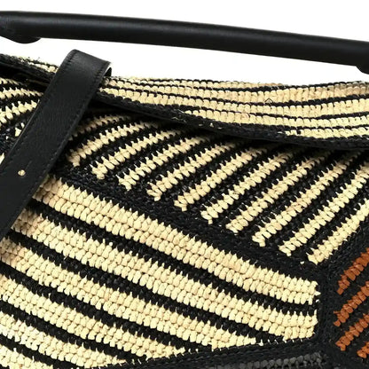 Small raffia puzzle bag front with black leather strap, natural and black chevron weave
