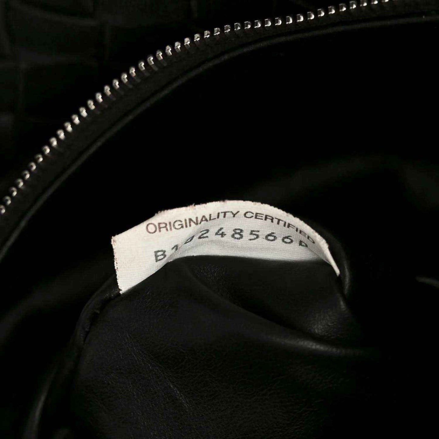 Black leather bag with zipper pull and authenticity label inside