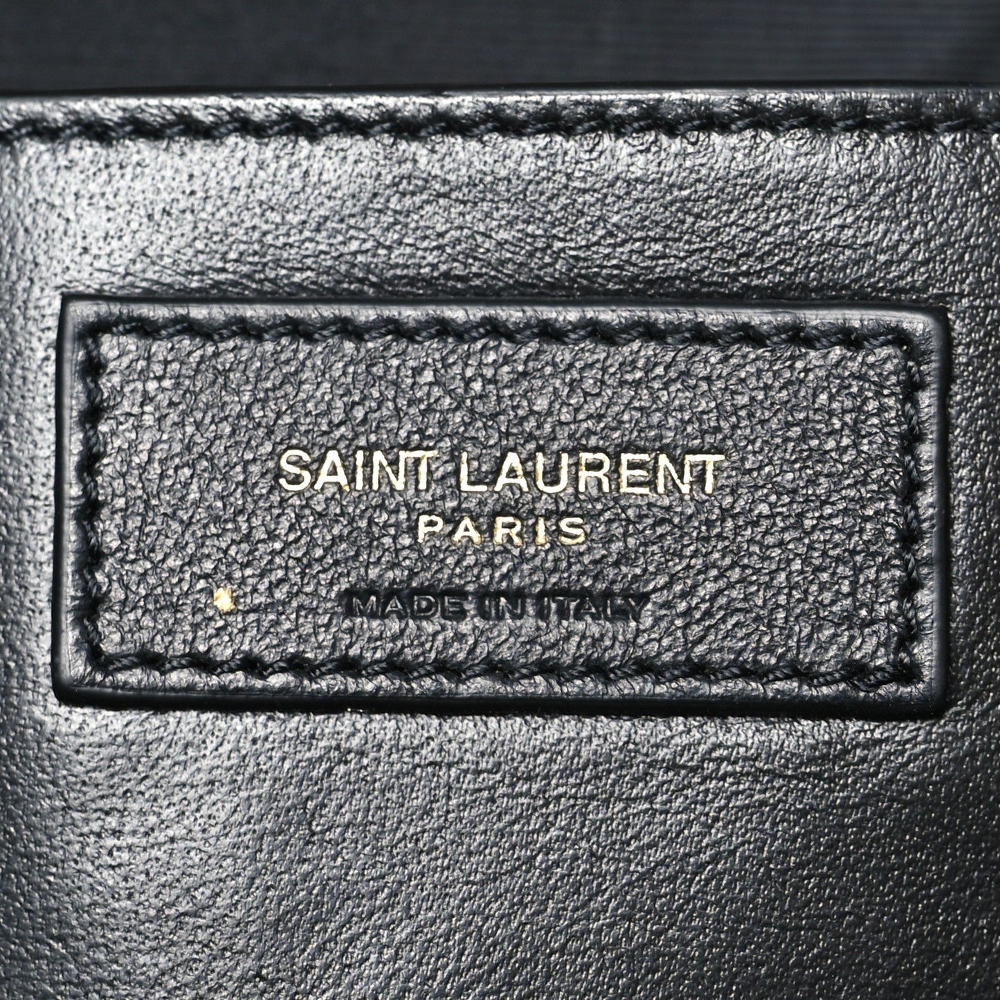 Saint Laurent Paris made in Italy leather label patch on dark-brown bag interior