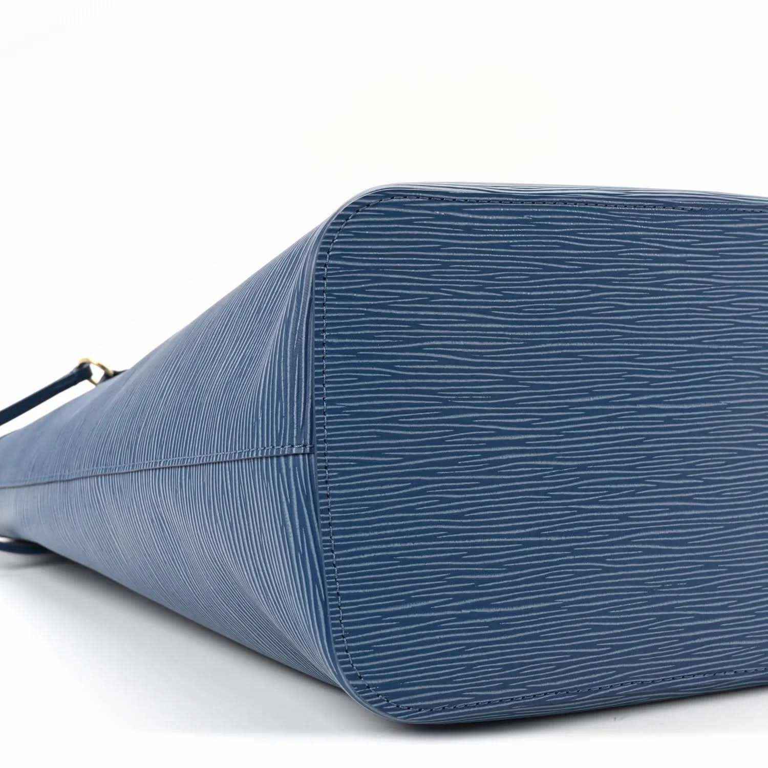 Denim blue leather tote bag close-up of textured side panel and zipper opening