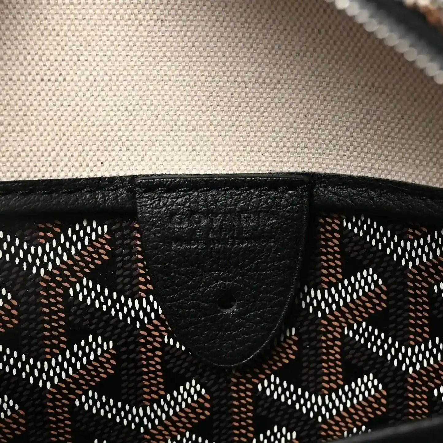 Black leather trim detail on patterned canvas tote bag.