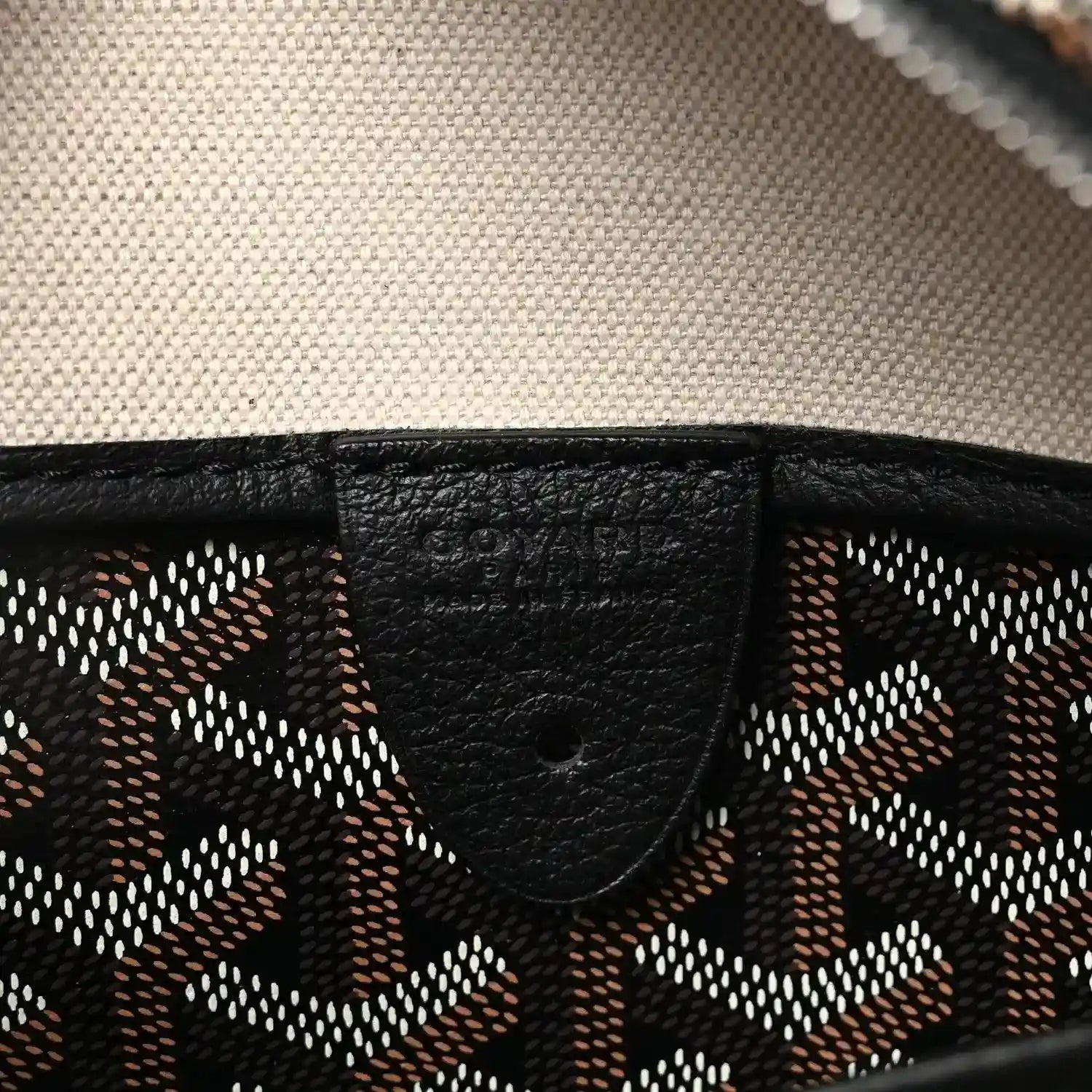 Black leather trim detail on patterned canvas tote bag.