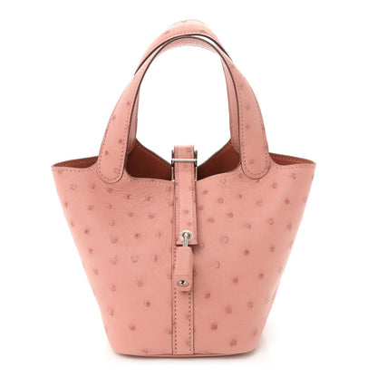 Light pink ostrich leather mini bucket bag with central lock closure and dual handles