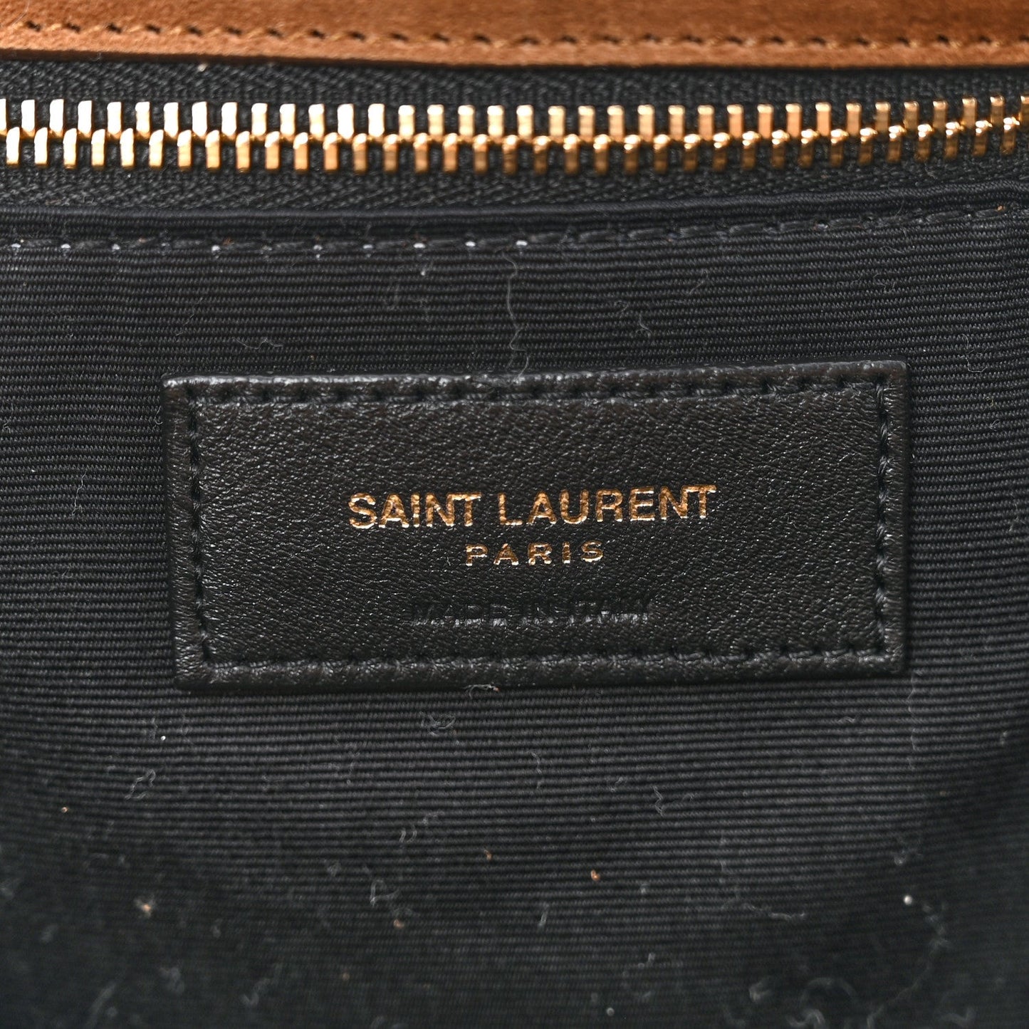 Saint Laurent interior fabric label on dark lining with gold zipper hardware.