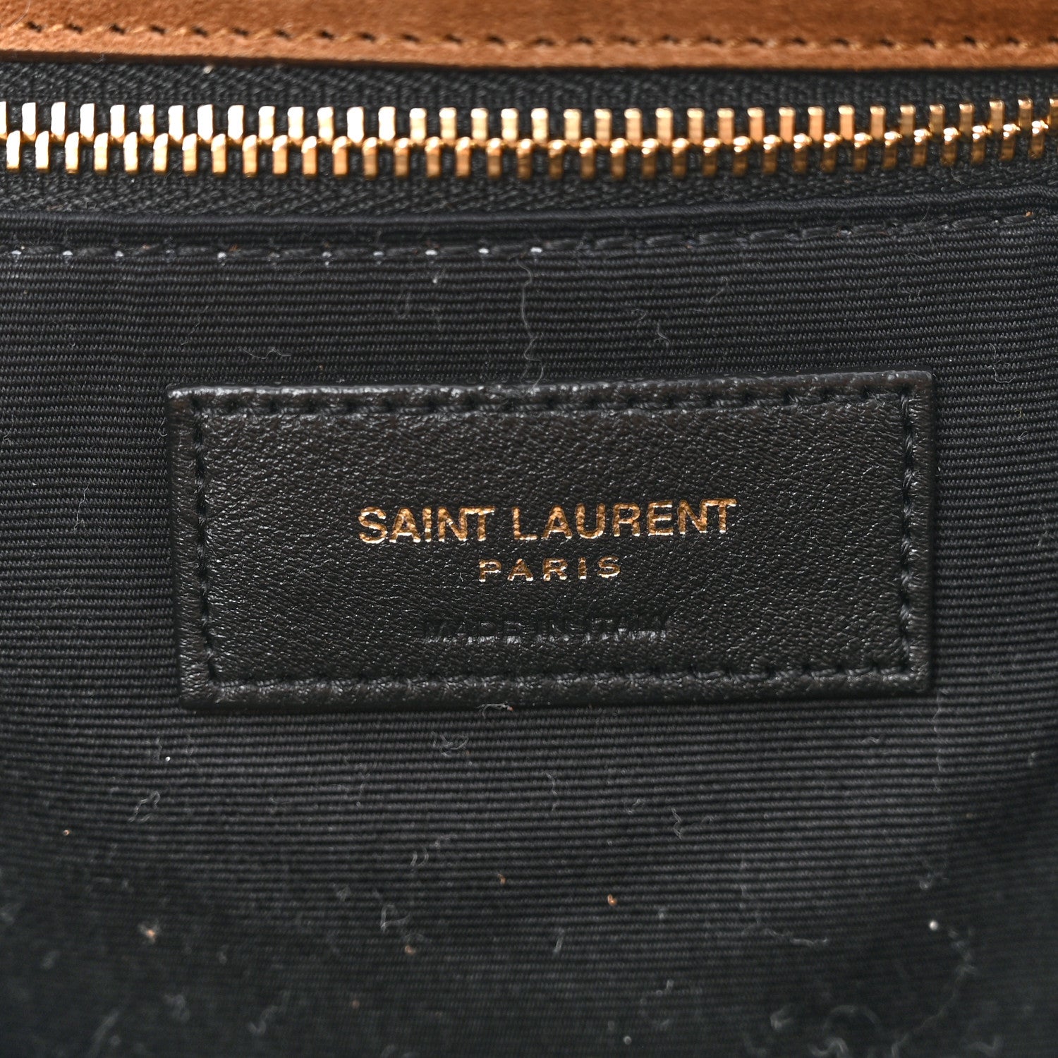 Saint Laurent interior fabric label on dark lining with gold zipper hardware.