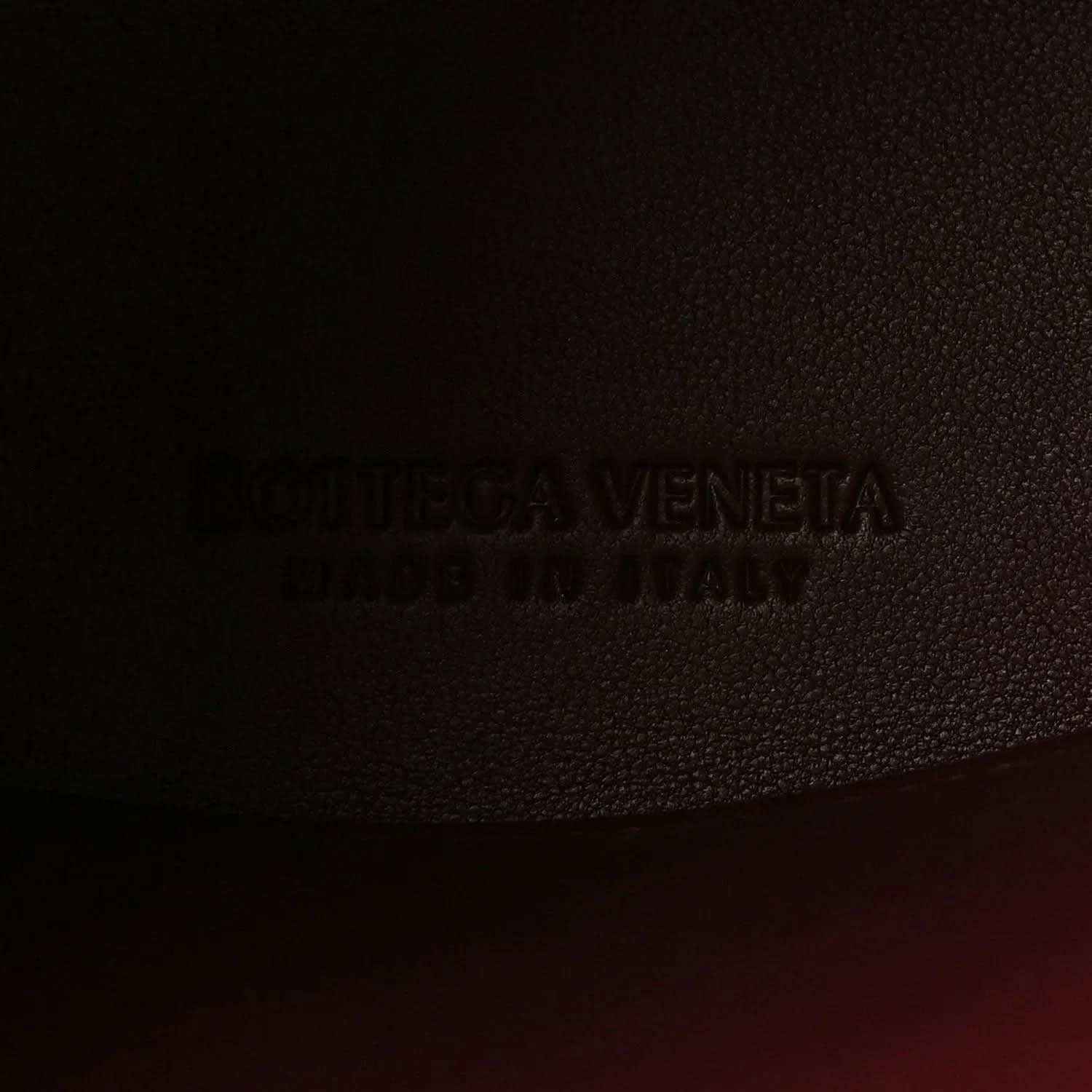 Bottega Veneta logo stamp on burgundy textured leather lining.