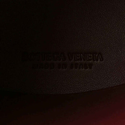 Bottega Veneta logo stamp on burgundy textured leather lining.