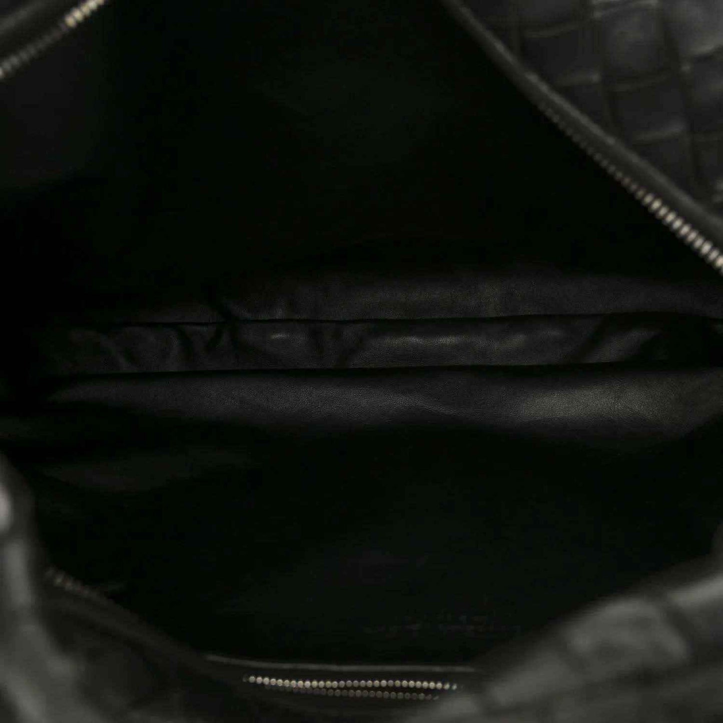 Black leather shoulder bag interior with zipper opening and stitched edge