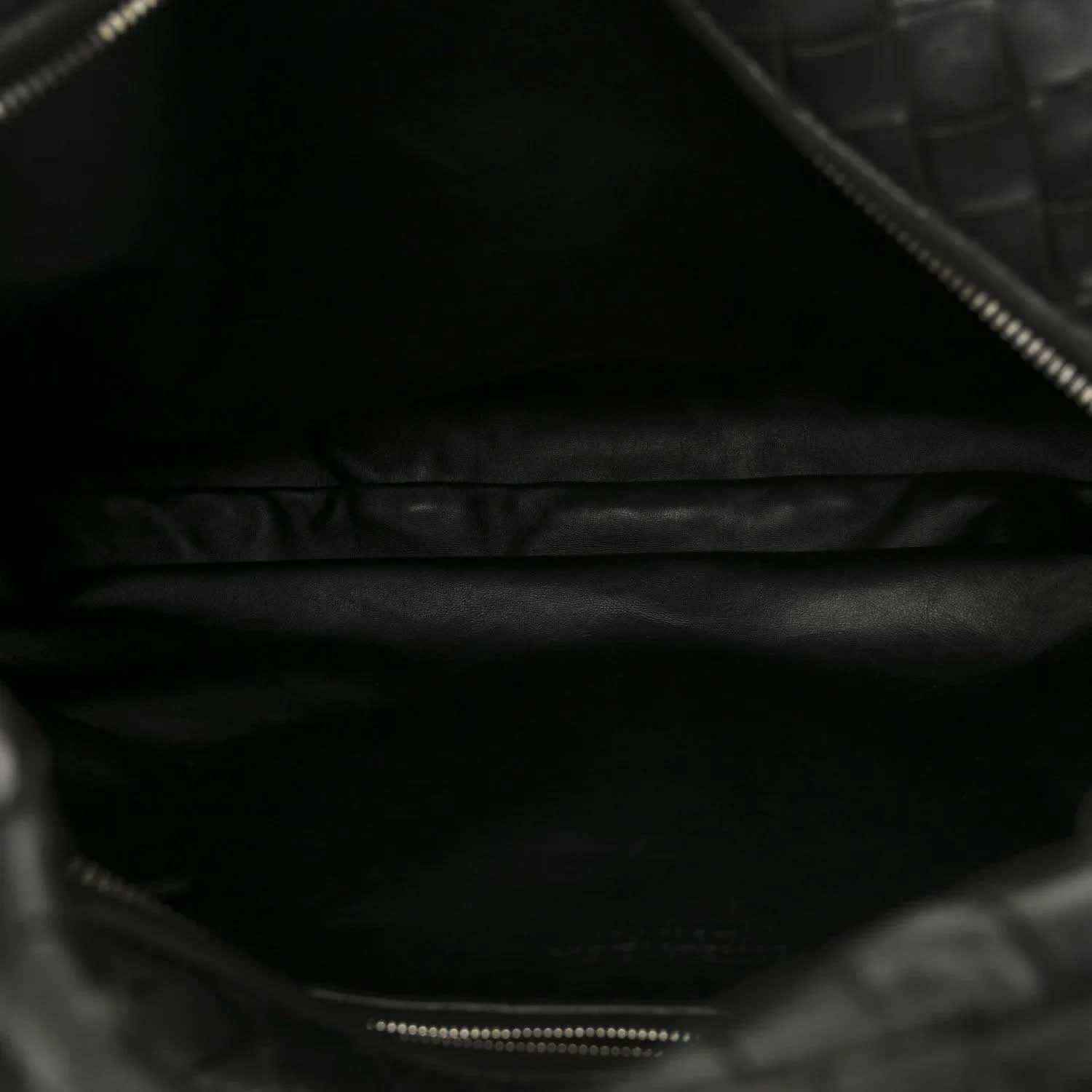 Black leather shoulder bag interior with zipper opening and stitched edge