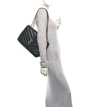 Black quilted leather shoulder bag with chain strap, side view on a model