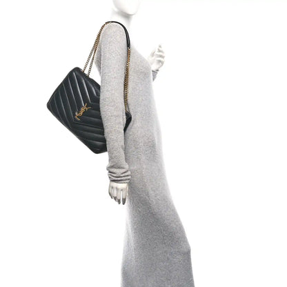 Black quilted leather shoulder bag with chain strap, side view on a model