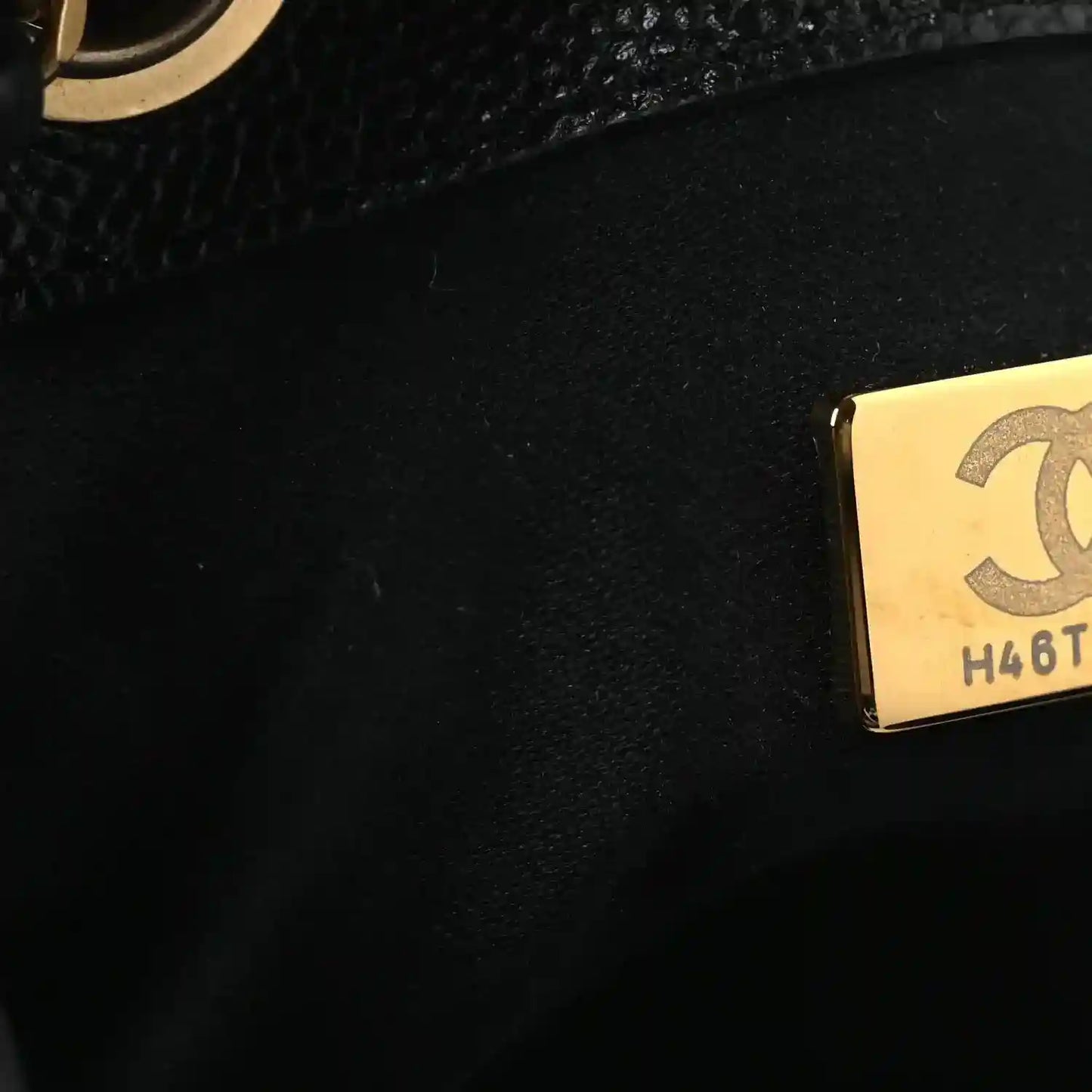 Black leather handbag lining with gold Chanel tag reading H4BT