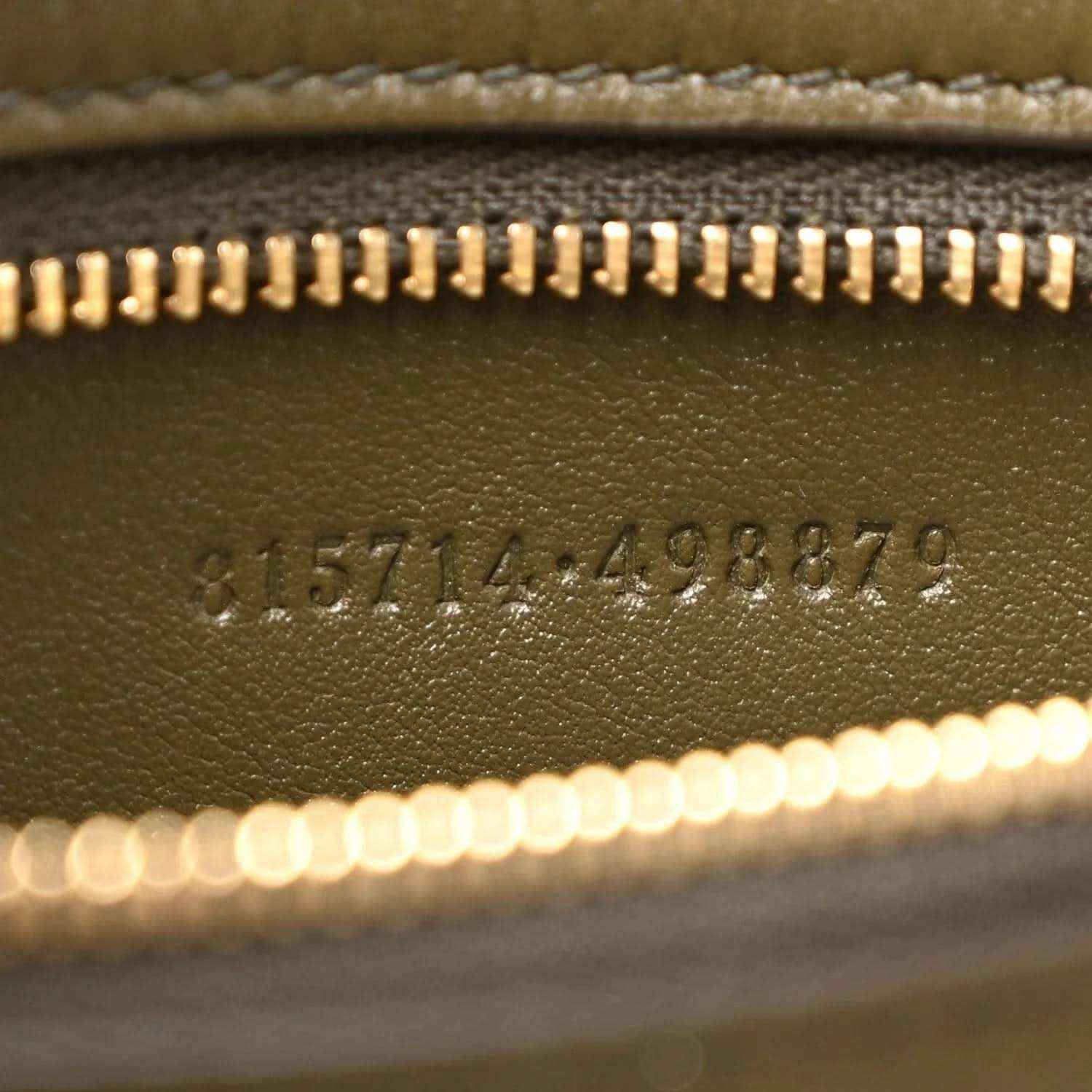 Embossed serial number detail on green leather handbag