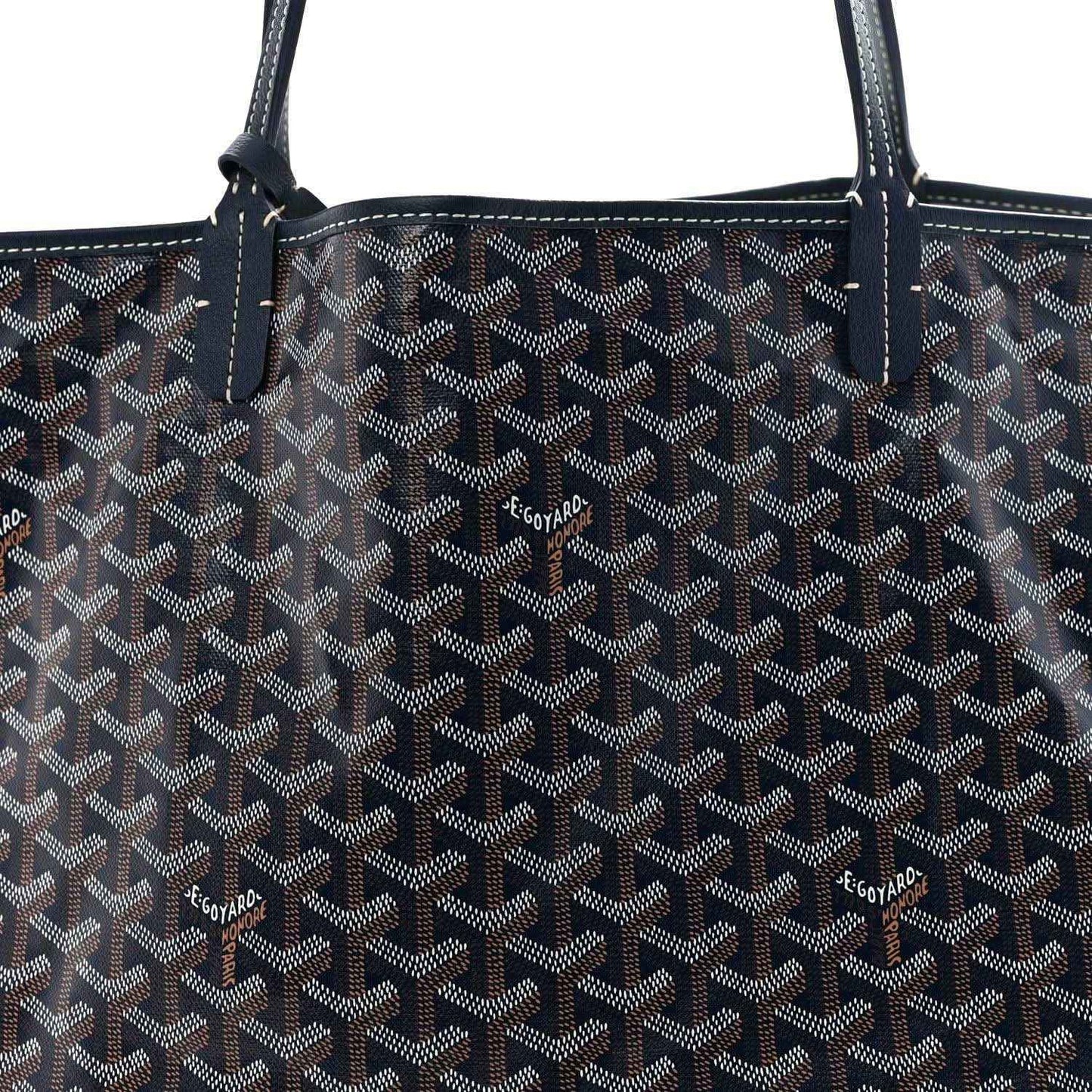 Navy Goyardine tote bag with repeating logo pattern and leather handle stitching.